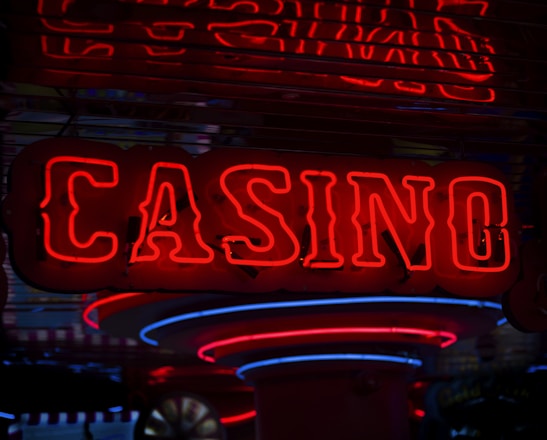 Neon lights display the word 'CASINO' in bright red, standing out against a dark background. The vibrant glow reflects a lively and bustling atmosphere.